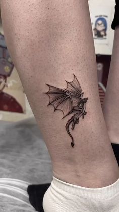 a woman's leg with a dragon tattoo on it