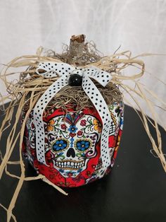 a pumpkin decorated with sugar skulls and ribbons