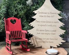 a red wooden rocking chair next to a christmas tree with a poem written on it