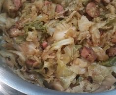 a bowl filled with meat and vegetables on top of a table next to a knife