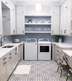 a laundry room with white cabinets and blue tile flooring is shown in front of the washer and dryer