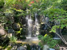 a small waterfall surrounded by rocks and trees