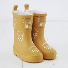 ☔ Colour-changing ochre wellies ☁️ Brushed fleece lining for warmth ☔ Easy-to-dry removable insoles ☁️Insoles help with left and right ☔Free drawstring bag Colour-changing wellies are back in brand new colours with a winter twist!  Our winter wellies have a thick teddy bear fleece lining for extra warmth on cold days.  In these ochre yellow kids wellies little ones can splash in puddles, rain, and snow whilst marvelling at the colour-changing raindrop patten.  Winter welly boots are available in infant sizes 3-13. Welly Boots, Yellow Kids, Running In The Rain, Adventure Boots, Wellies Boots, Kids Fleece, Color Magic, Clouds Design, Winter Walk