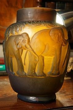 an elephant vase sitting on top of a wooden table