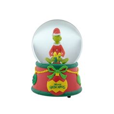 a christmas snow globe with an image of the grin on it's top and green trimmings