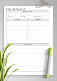 a printable project planner on a clipboard next to a plant