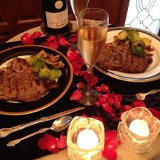 a table topped with plates of food next to candles and wine glasses on top of a table