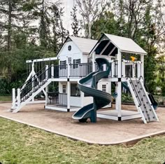 a white house with a slide in the front and stairs to the second story on the other side