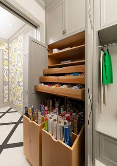 an organized pantry with lots of drawers and items in the bottom drawer, along with wallpaper on the walls