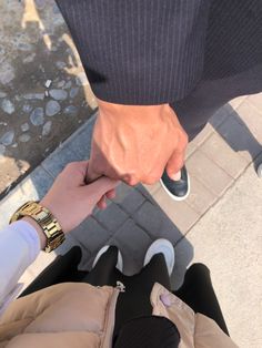 two people holding hands while standing next to each other