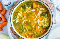 a bowl of soup with carrots and broccoli