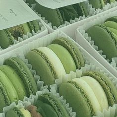 there are many green and white macaroons in the box