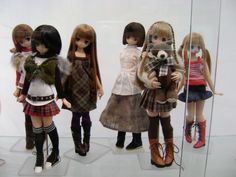 several dolls are on display in a glass case