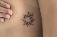 a woman's stomach with a small sun tattoo on it