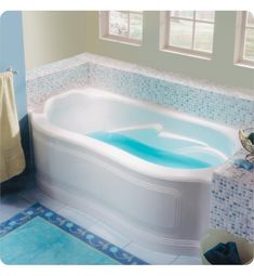 a bathroom with a large jacuzzi tub next to a window and tiled floor