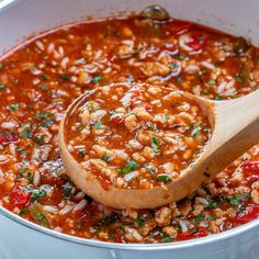 a wooden spoon in a pot filled with beans and rice