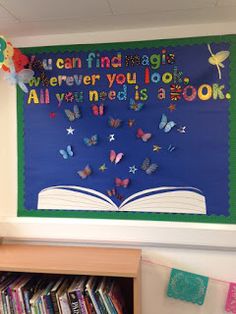 an open book with butterflies on it in front of a bulletin board