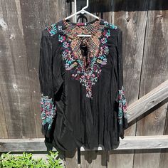 Black Peasant Top With Detailed Floral Embroidery On Front And Arms. Ties In The Front. Im Excellent Condition. Please No Low Offers. Black V-neck Blouse With Floral Embroidery, Black Top With Intricate Embroidery, Black Blouse With Intricate Embroidery For Festival, Black Long Sleeve Embroidered Top With Floral Print, Bohemian Black Tops With Embroidered Neckline, Black Long Sleeve Top With Intricate Embroidery, Black Floral Print Festival Blouse, Black Tops With Intricate Embroidery For Festival, Black Floral Print Blouse For Festival