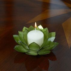 a lit candle sitting on top of a wooden table