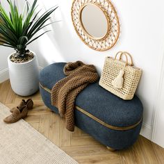 a blue ottoman sitting next to a potted plant on top of a hard wood floor