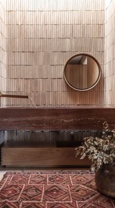 a wooden bench sitting in front of a mirror on top of a wall next to a potted plant