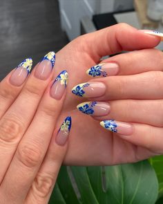 Almond-shaped nails with blue and yellow floral designs on a nude base, showcasing trendy, tropical-inspired nail art. Beach Acrylic Nail Designs, Nail Art Designs Tropical, Almond Tropical Nails, Teal Floral Nails, Blue Flower Summer Nails, Summer Nails Beach Vibes, Cute Bday Nails Short, Hawaiian Manicure, Vacation Nails Beach Mexico Almond