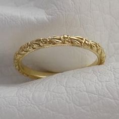 a gold wedding ring sitting on top of a white cloth