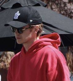 a man in a red hoodie and black hat