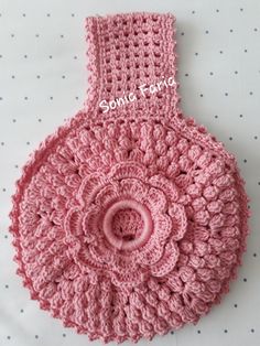 a pink crocheted bag with a flower on it