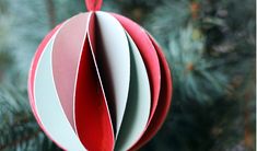 a red and white ornament hanging from a christmas tree