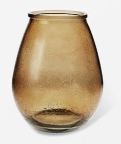 a brown glass vase sitting on top of a white table