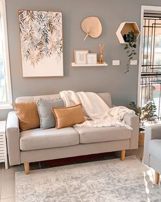 a living room with two couches and a rug on the floor in front of a window