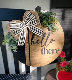 a wooden sign that says hello there with a bow on it and succulents