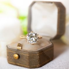 an engagement ring sitting on top of a wooden box