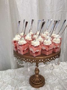 there are many cupcakes that have been placed on a cake stand with forks in them