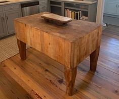 a wooden table sitting on top of a hard wood floor next to a kitchen counter