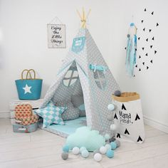 a child's teepee tent with blue and white polka dots on the floor