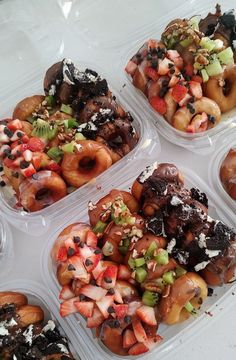 four plastic containers filled with donuts covered in toppings