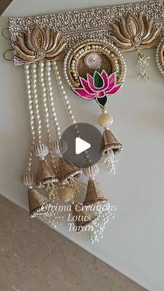 an intricately decorated wall hanging with bells and pearls