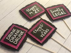 four pink and black cupcake toppers on sticks