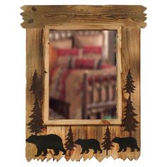 a wooden frame with bear silhouettes on it and a bed in the back ground