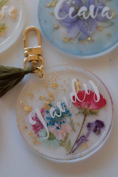 three glass plates with flowers on them and the words happy written in white letters are next to a green tassel