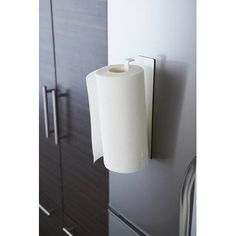 a roll of toilet paper is hanging on the wall next to a cabinet with drawers