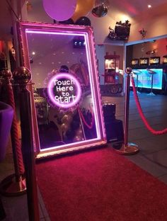 there is a pink neon sign in the mirror