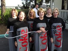 a group of women standing next to each other in front of a building holding onto two large signs