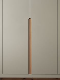 a tall wooden pole in the middle of a room with white walls and wood flooring