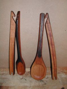 three wooden spoons are lined up on a table