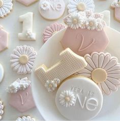 some cookies are on a plate with flowers and the number one is decorated in frosting