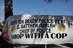 a sign that reads, boyton beach police dept g matthew miller chief of police shop with a cop