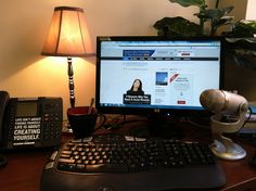 a desktop computer sitting on top of a desk next to a lamp and telephone receiver